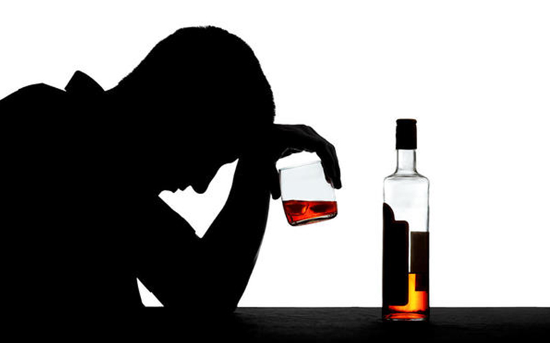 man sitting and drinking alcohol by himself