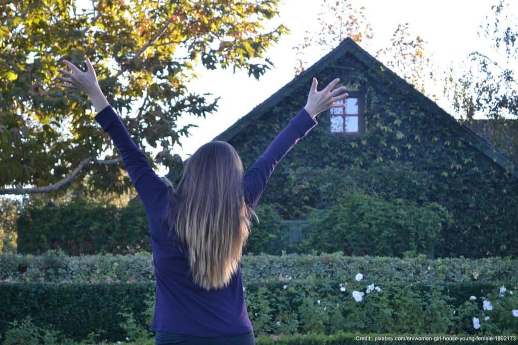 Happy woman in front of a sober living facility.