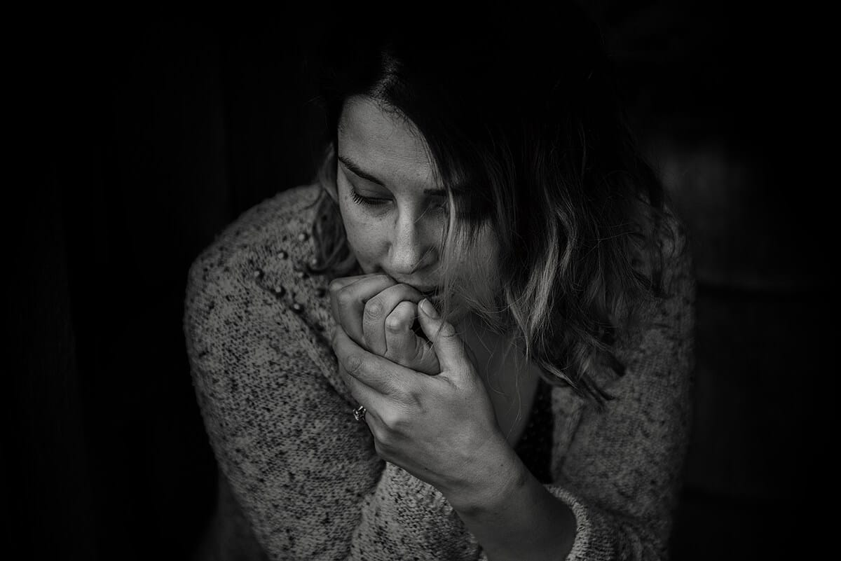 a woman is sitting on the corner with depressed feeling.