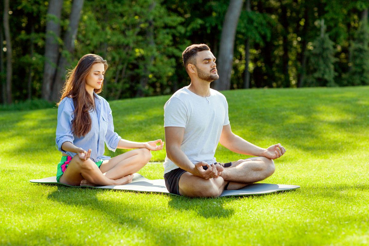 A man and woman are doing meditation to practice the mindfulness that helps cope with depression at The Dawn Mental Health Retreat Thailand.