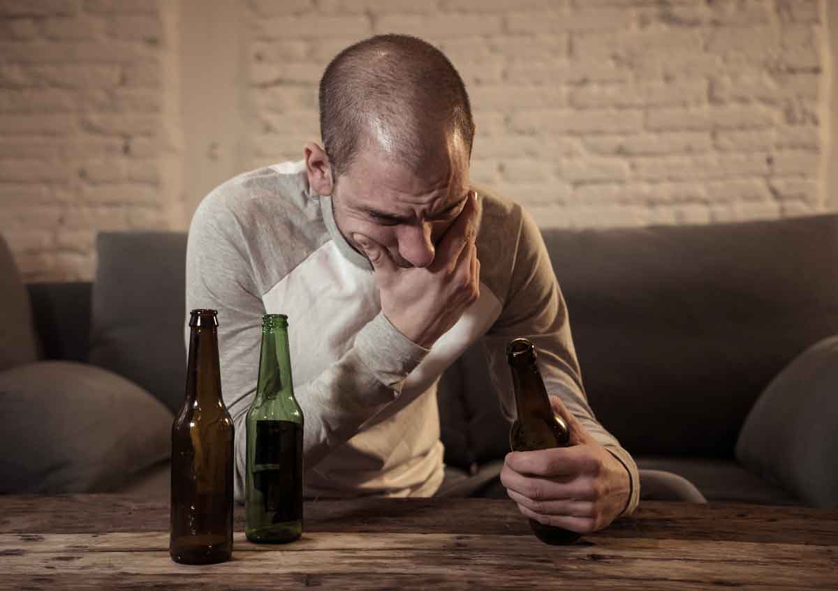 depressed man drinking alcohol at home