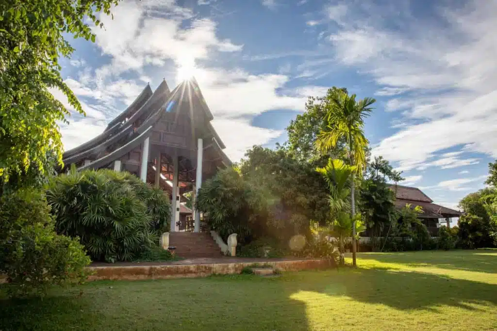 Sunlit traditional Thai pavilion surrounded by lush greenery at The Dawn.